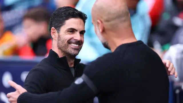 : Mikel Arteta manager / head coach of Arsenal shakes hands with Pep Guardiola manager of Manchester City