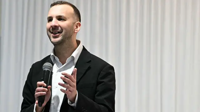Zack Polanski speaks into a microphone