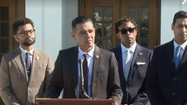 Robert Garcia standing at a podium with other Democrats behind him
