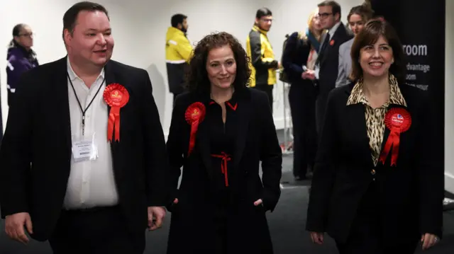 Labour Party candidate Angeliki Stogia walks with Deputy Labour Party leader Lucy Powell and Labour MP Andrew Western, during vote counting in the Gorton and Denton by-election