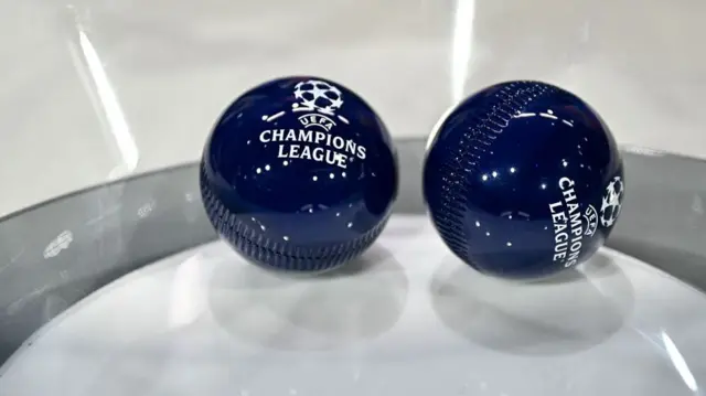 This photograph shows the draw balls bearing the competition logo ahead of the 2025-2026 UEFA Champions League round of 16, quarter-final and semi-final draw