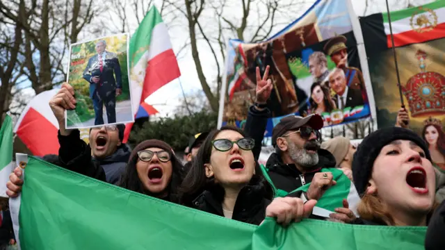 Demonstrators react as they gather in support of military action against the Iranian regime, following strikes by the U.S. and Israel against Iran, outside the Iranian embassy in London