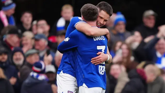 George Hirst is hugged by Leif Davis