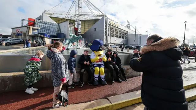 Preston fans pose for a picture outside Deepdale