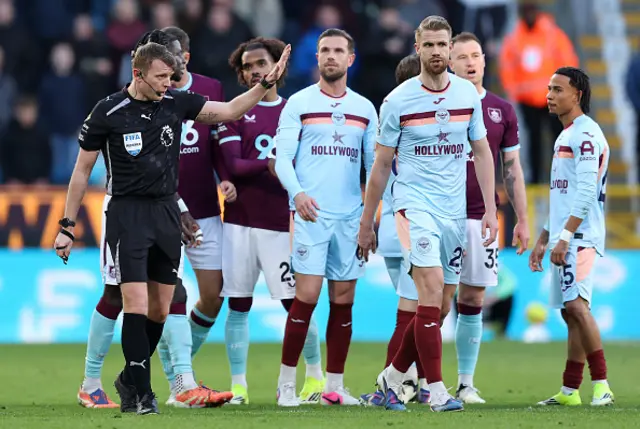 Referee Samuel Barrott heads to the screen to look at a goal scored by Ashley Barnes