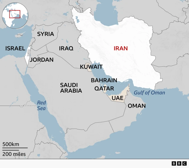 A regional map highlighting Iran in white with its name in red. Countries that have come under fire from Iran are labelled in beige - Kuwait, Bahrain, Qatar, UAE. Surrounding countries are labeled in grey, neighbouring Iraq to the west and other Middle Eastern countries including Syria, Jordan, Saudi Arabia and Oman. Bodies of water such as the Red Sea and the Gulf of Oman are marked in blue.