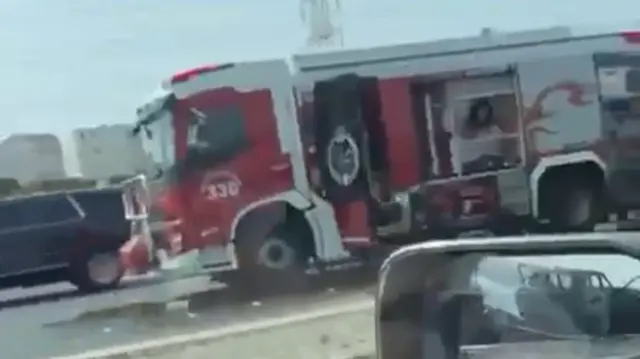 Vehicle that appears to be fire truck, in image taken from road in Kuwait following apparent strike