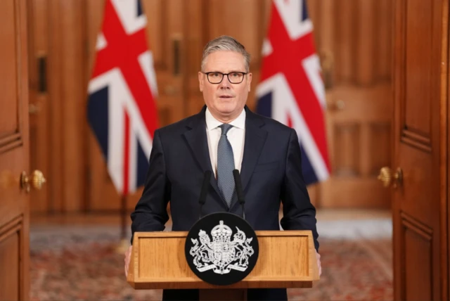 Keir Starmer speaking behind a wooden lectern inside No 10