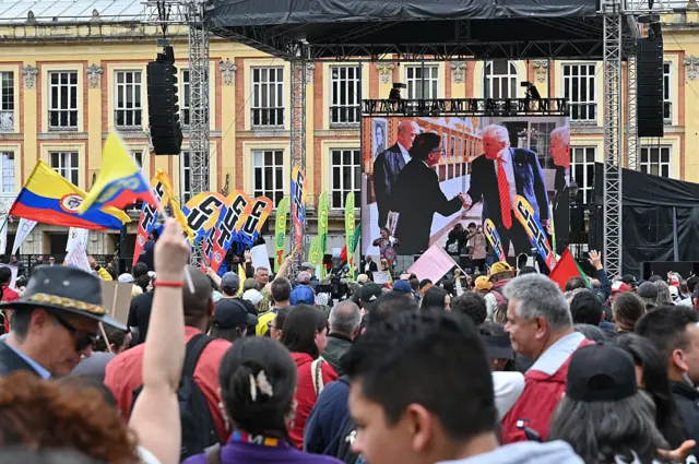कोलंबिया के राष्ट्रपति गुस्तावो पेट्रो के समर्थक स्क्रीन पर उन्हें और अमेरिकी राष्ट्रपति डोनाल्ड ट्रंप को हाथ मिलाते हुए देख रहे हैं
