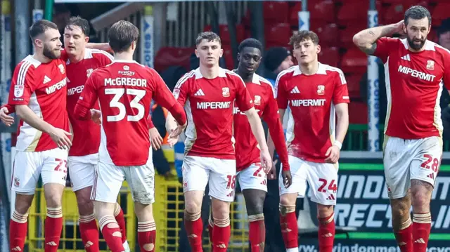 Swindon Town players celebrate scoring in their 3-1 win over Barrow
