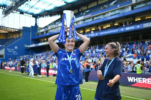 Lucy Bronze holds the WSL trophy on her head