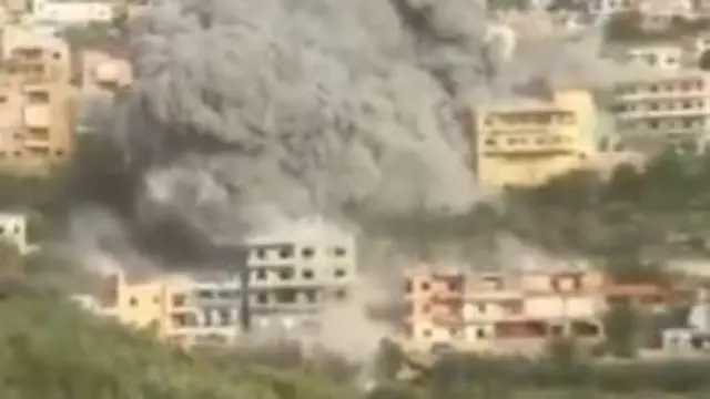 A smoke cloud rises over buildings in Ain Qana