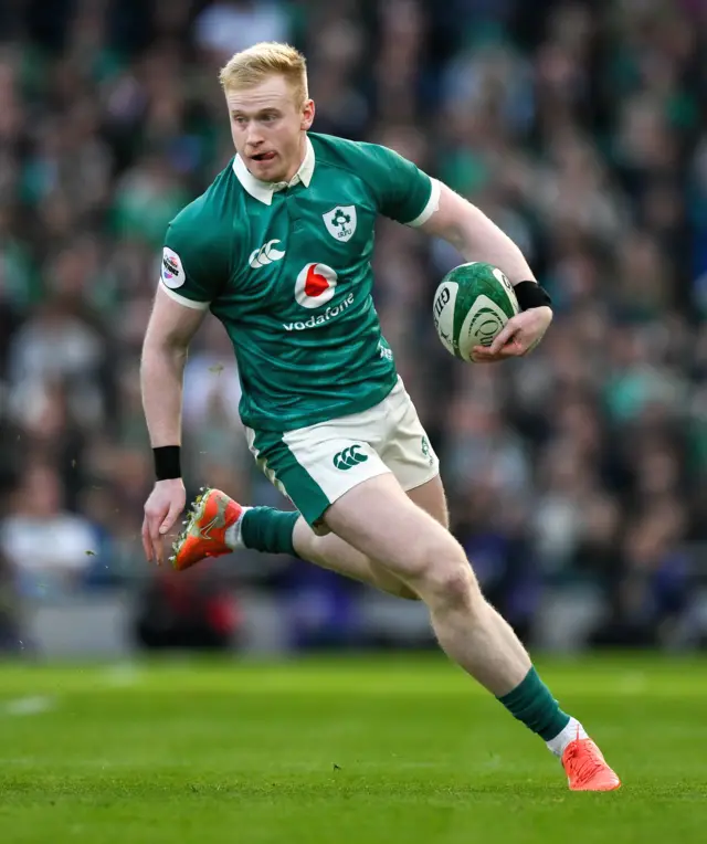 Jamie Osborne carrying the ball in his left hand and stepping towards his right