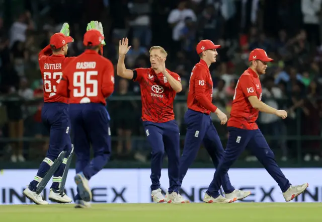 England's Luke Wood celebrates with teammates after taking the wicket of Sri Lanka's Kamil Mishara caught out by England's Ben Duckett