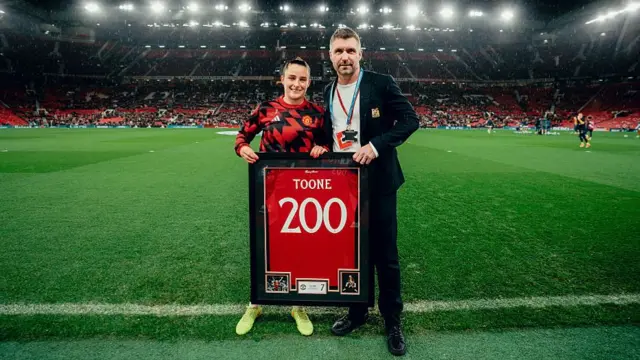 Toone poses with her 200th club appearance shirt