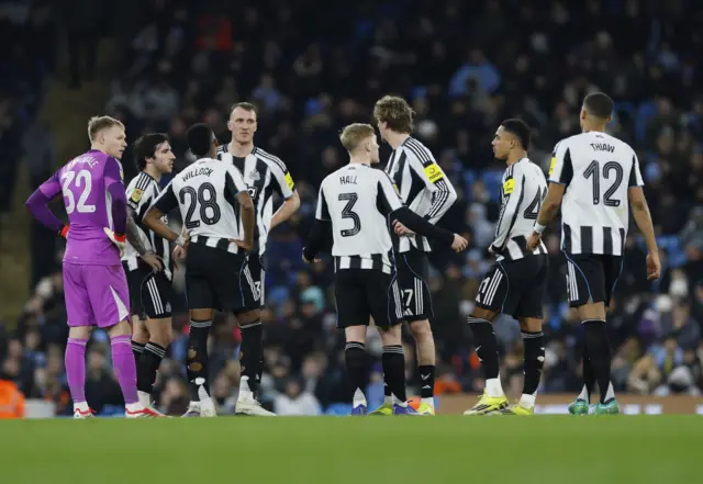 Newcastle United's Dan Burn with teammates during a break in play