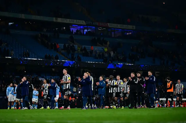 Newcastle players and staff clap the fans