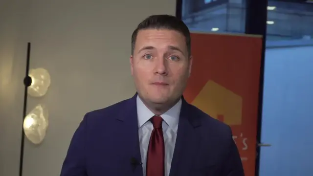 Wes Streeting in suit answering questions inside a room
