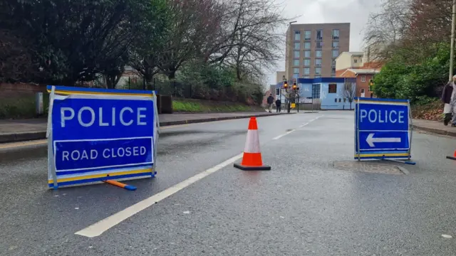 Road closure with blue police signs in the middle of the road