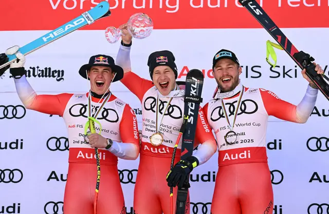 Second place, Switzerland's Franjo von Allmen; first place Switzerland's Marco Odermatt; and third place Switzerland's Alexis Monney celebrate on the podium
