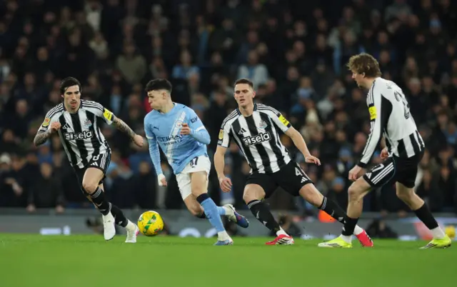 Manchester City's Phil Foden in action with Newcastle United's Sandro Tonali and Sven Botman