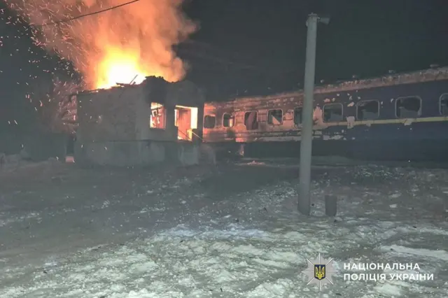 A building is on fire next to train carriages following a drone attack