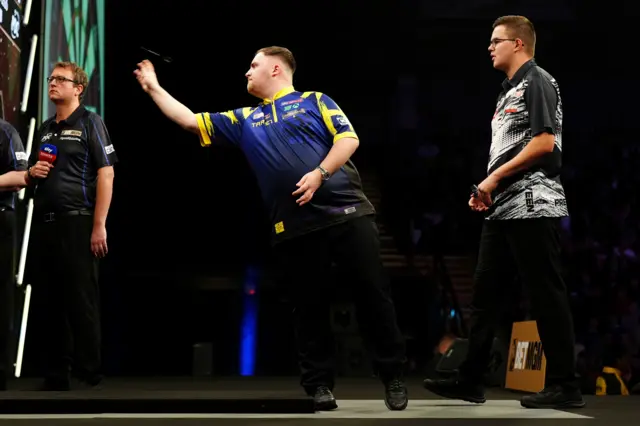 England's Luke Littler (centre) during his match against Netherlands' Gian van Veen (right) during the BetMGM Premier League Darts at the Utilita Arena, Newcastle upon Tyne
