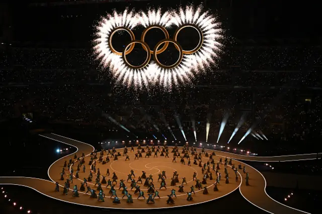 The Olympic Rings is revealed above dancers during the opening ceremony of the Milano Cortina