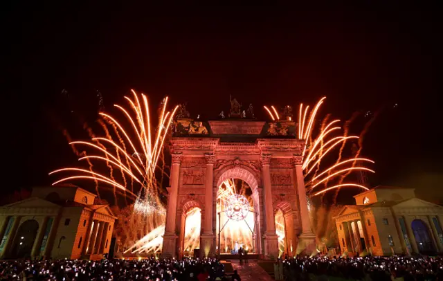 A firework display is seen at the Arco della Pace after the lighting of the Olympic cauldron