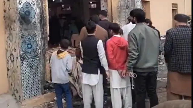 A screengrab from the video showing worshippers clustered outside the mosque's doors after the blast