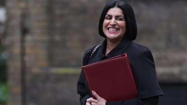 Shabana Mahmood holds a red leather bound folder