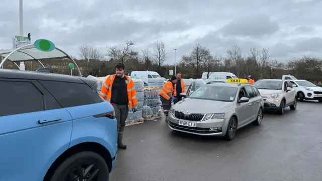 A queue of cars collecting bottled water