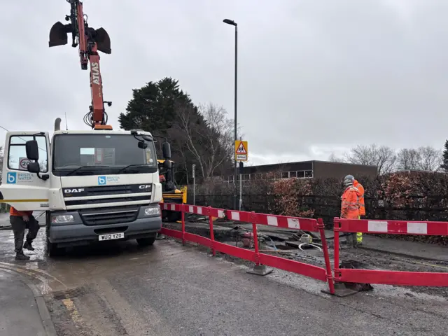 A large Bristol Water lorry and crane at the scene of a burst water main