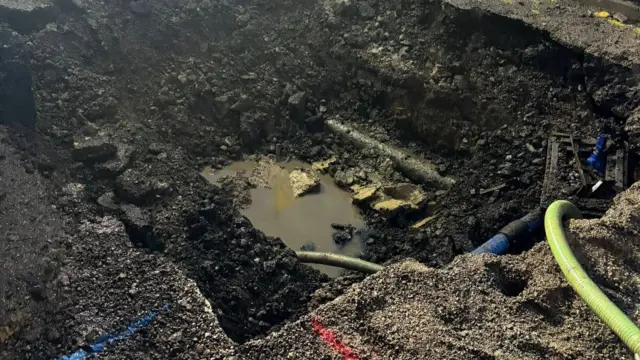 Crews working at the scene of a burst water main