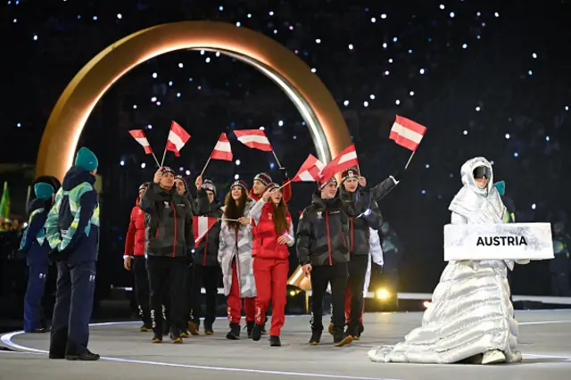 Austria's Jeannine Rosner (C), Austria's Alexander Farthofer (Front R) and fellow Austrian athletes parade