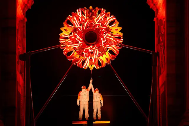 Torchbearers Deborah Compagnoni and Alberto Tomba light the Olympic cauldron at the Arco della Pace