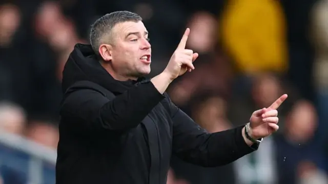 Steven Schumacher shouting and pointing in different directions