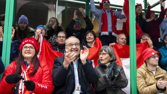 Swiss President Guy Parmelin and his wife Caroline with Swiss fans during a public viewing of the men's alpine skiing downhill race at the 2026 Olympic Winter Game