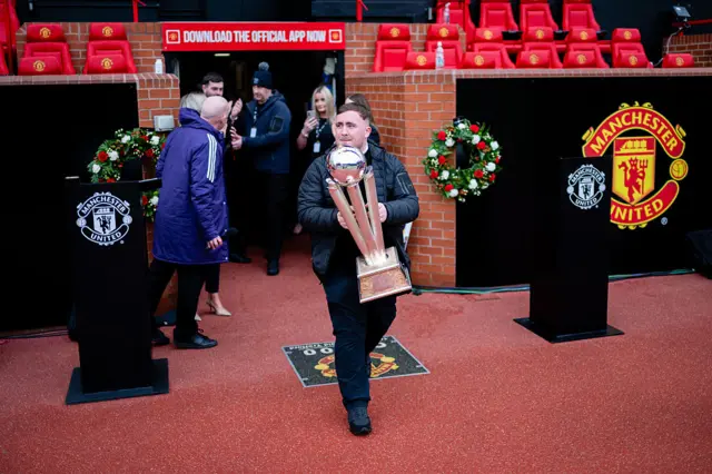 Luke Littler carries the PDC Darts Championship trophy