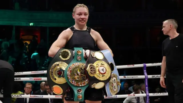 Lauren Price holding her welterweight titles