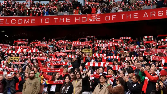 Arsenal fans sing with scarves