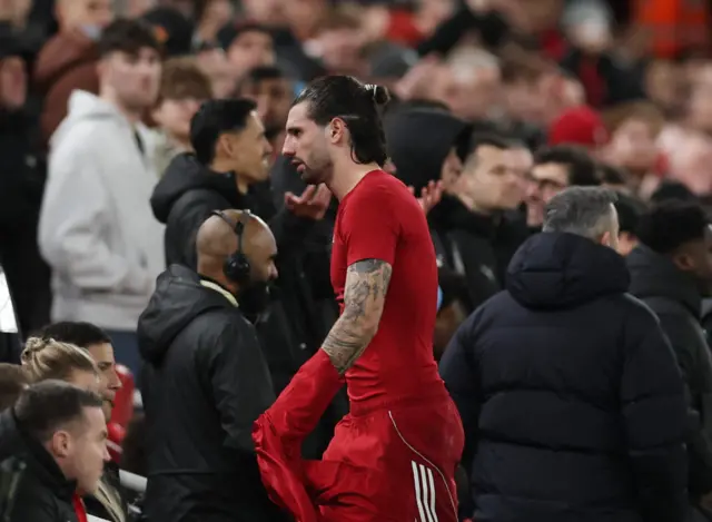 Liverpool's Dominik Szoboszlai reacts as he walks off the pitch after being sent off upon VAR review.