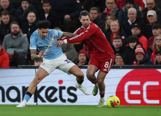 Manchester City's Nico O'Reilly in action with Liverpool's Dominik Szoboszlai.