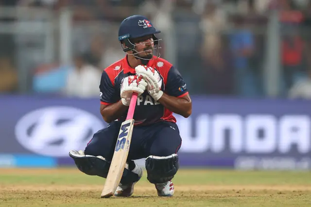 Lokesh Bam sits on his haunches after defeat to England