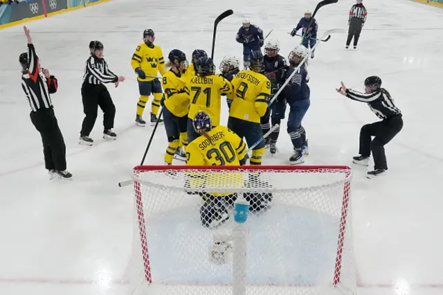 Players scuffle during a preliminary round match of women's ice hockey between France and Sweden