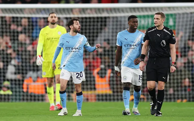 Bernardo Silva and Marc Guehi of Manchester City remonstrate with referee, Craig Pawson, after Dominik Szoboszlai of Liverpool (not pictured) scores his teams first goal during the Premier League match between Liverpool and Manchester City at Anfield on February 08, 2026 in Liverpool, England.