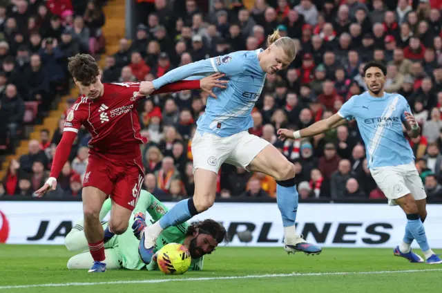 Liverpool's Milos Kerkez and Alisson Becker in action with Manchester City's Erling Haaland.