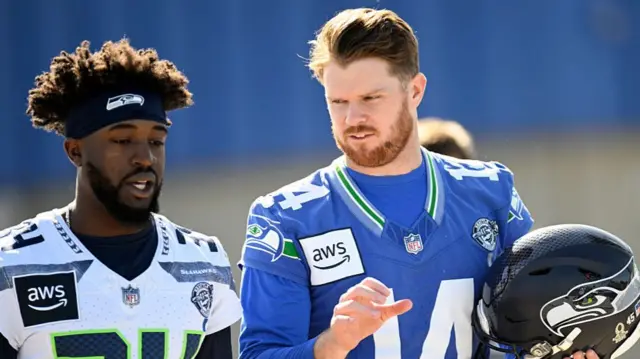 Sam Darnold speaks to Shemar Jean-Charles at a Seattle Seahawks practice before Super Bowl 60
