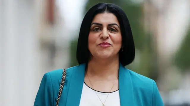 British Home Secretary Shabana Mahmood pictured wearing a turquoise blazer and a white top.