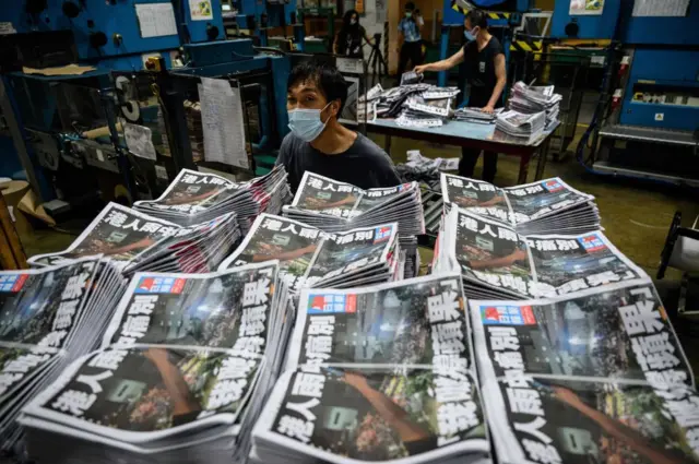 Apple Daily employees work in the printing room as the last edition of the newspaper is printed in Hong Kong